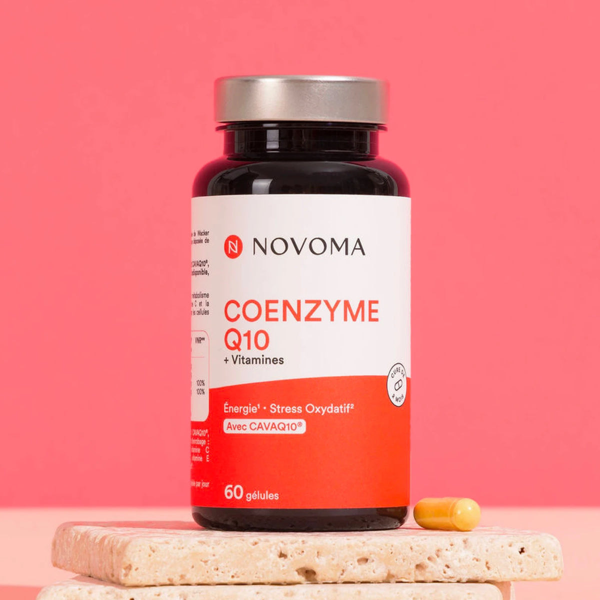 Pilulier de Coenzyme Q10 Novoma sur une pierre, fond rose