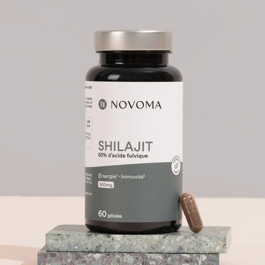 Pilulier de Shilajit Novoma posé sur une pierre sombre