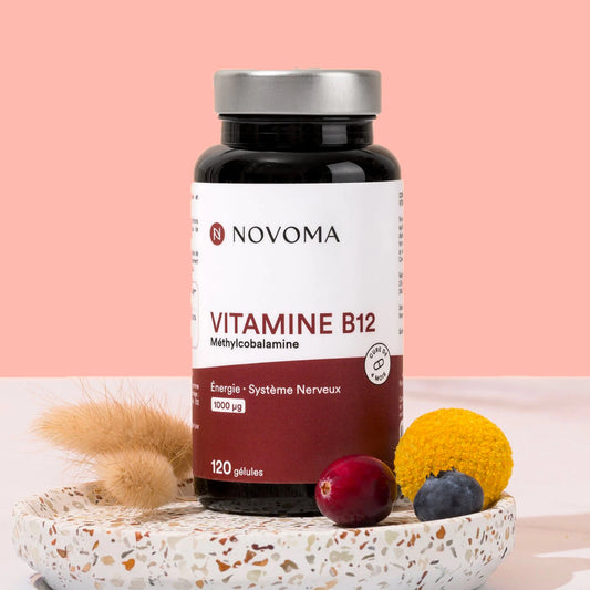 Pilulier de Vitamine B12 Novoma avec des fruits rouges sur fond rose