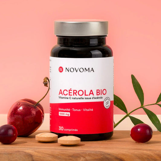 Acérola Bio Novoma entouré de fruits d'acérola frais et de comprimés à croquer
