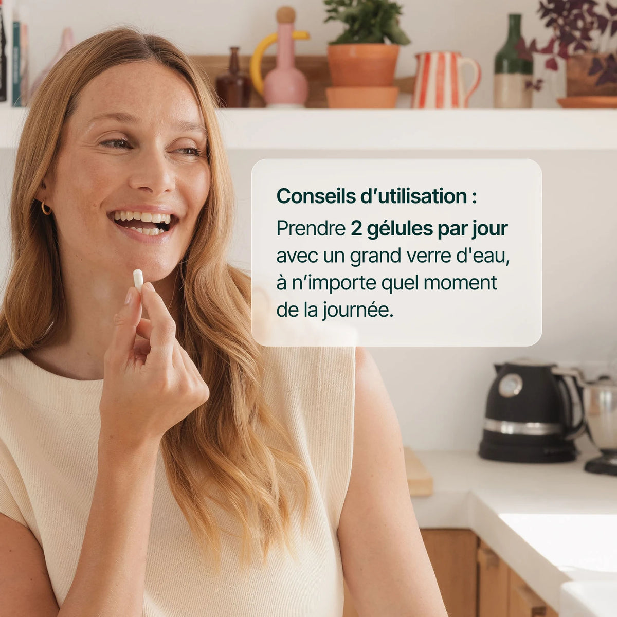 Femme souriante tenant une gélule d'acide hyaluronique : 2 gélules par jour avec un grand verre d'eau