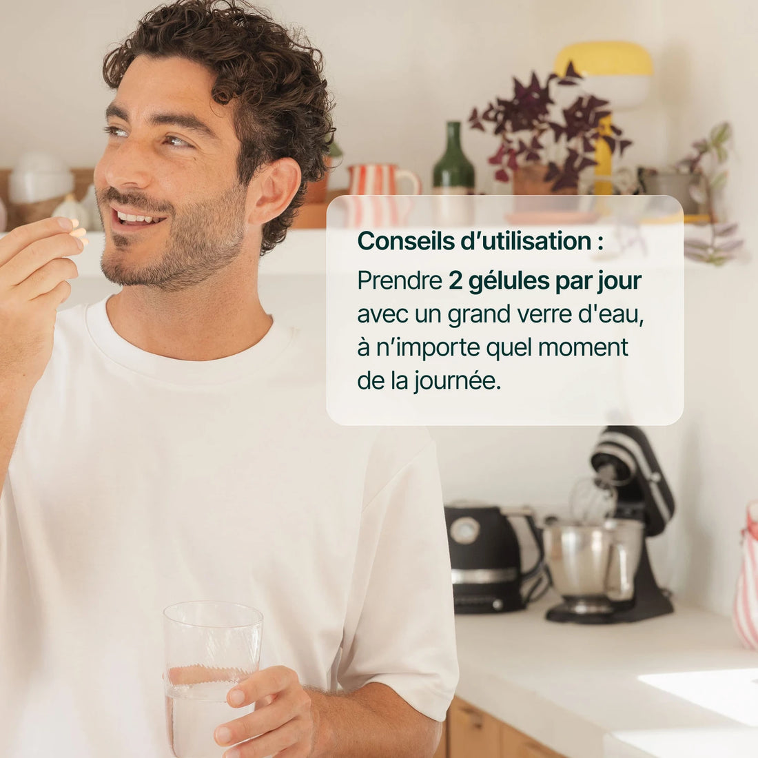 Homme souriant prenant une gélule d'ashwagandha : 2 gélules par jour avec un grand verre d'eau