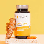 Pilulier de Curcuma Novoma posé près de racines de curcuma frais sur fond jaune