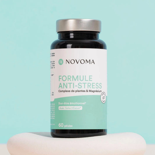 Pilulier de Formule Anti-Stress Novoma sur un socle, fond vert d'eau