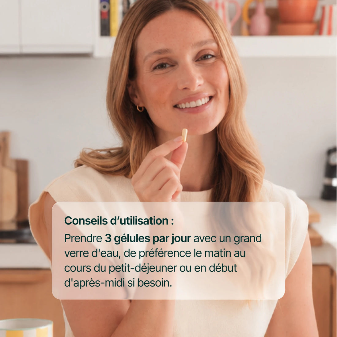 Femme souriante tenant une gélule : 3 gélules de Formule Boost Bio par jour, de préférence le matin