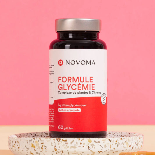 Pilulier de Formule Glycémie Novoma sur un socle, fond rose