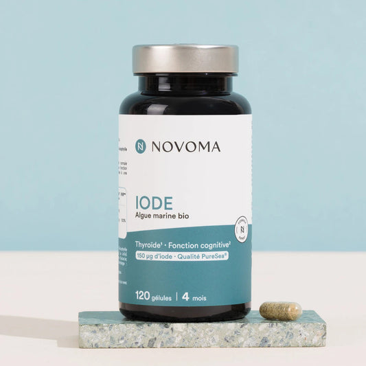 Pilulier d'Iode Novoma sur une pierre, fond bleu