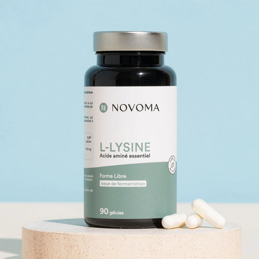 Pilulier de L-Lysine Novoma sur un socle, fond bleu clair