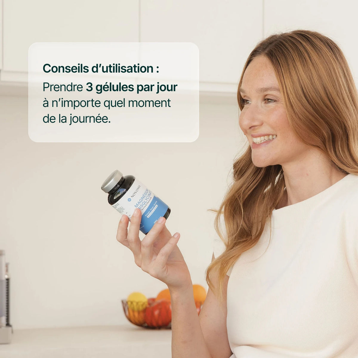 Femme souriante tenant une gélule de magnésium : 3 gélules par jour, à n'importe quel moment