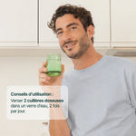 Homme buvant un verre : 2 cuillères doseuses d'OptiMSM® dans un verre d'eau, 2 fois par jour