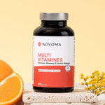 Pilulier de Multivitamines Novoma avec une demi-orange et du mimosa sur fond jaune