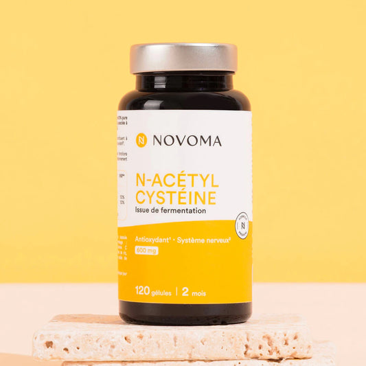 Pilulier de NAC N-acétylcystéine Novoma sur fond jaune