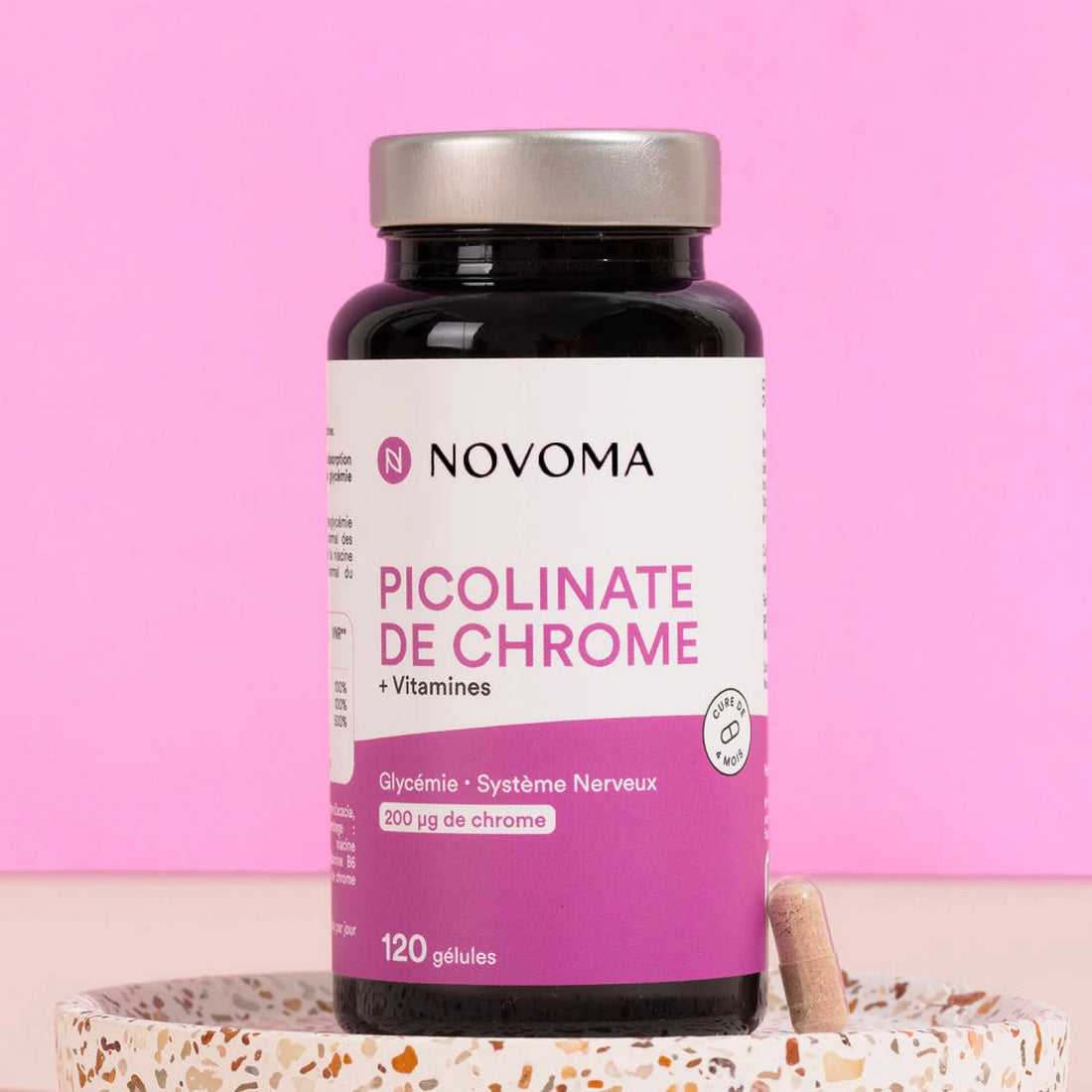 Pilulier de Picolinate de Chrome Novoma sur un socle, fond rose