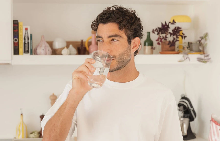 Homme avec un verre d'eau à la main