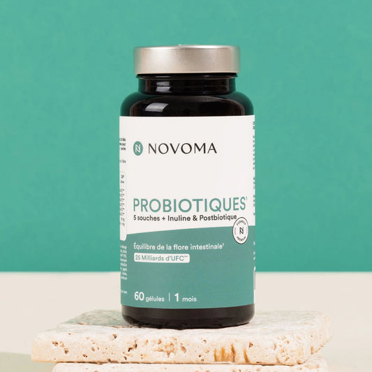 Pilulier de Probiotiques Novoma sur un socle, fond vert