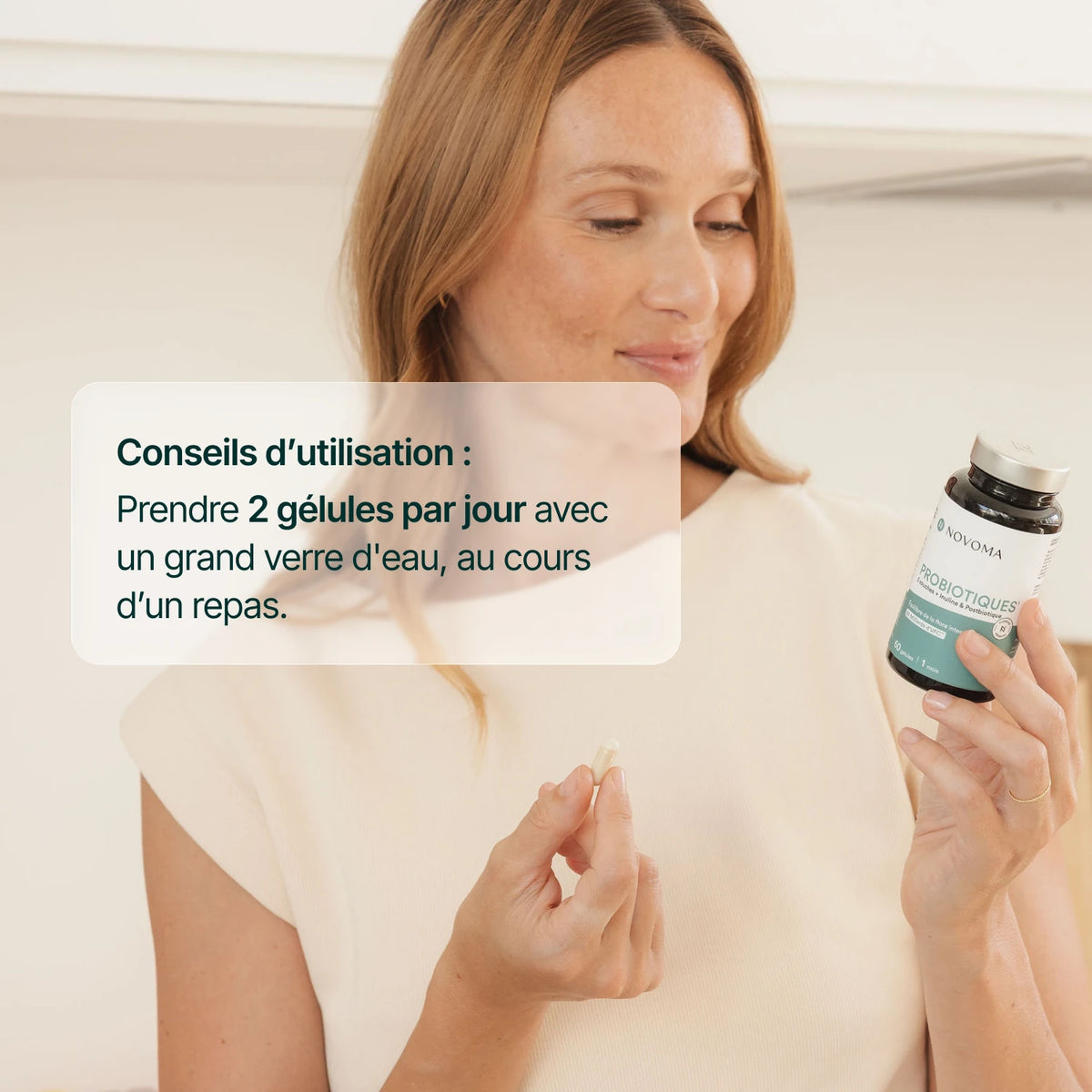 Femme souriante tenant le pilulier : 2 gélules de Probiotiques par jour au cours d'un repas