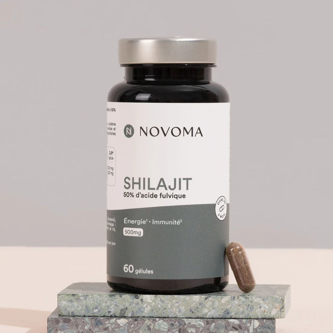 Pilulier de Shilajit Novoma posé sur une pierre sombre