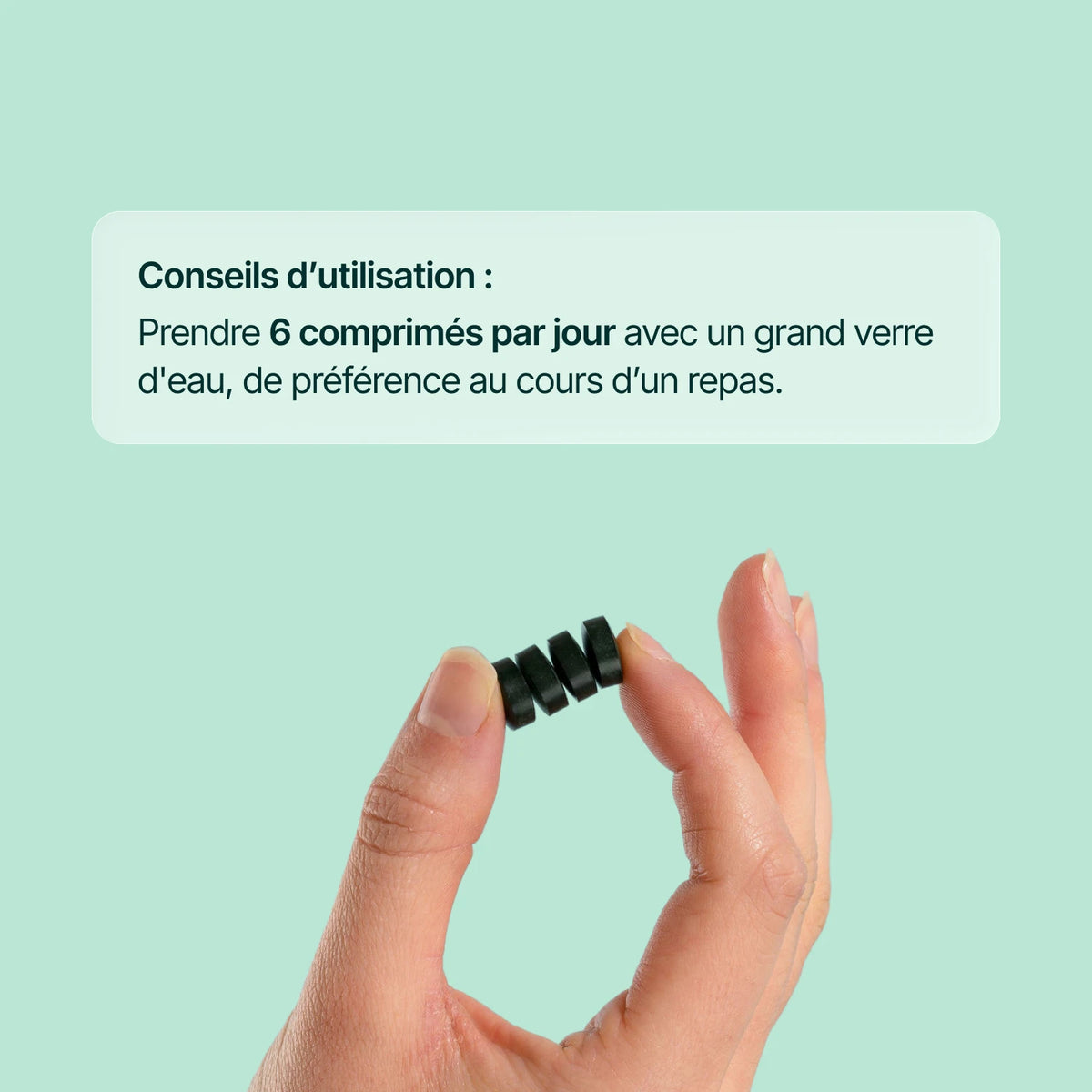 Comprimé de spiruline tenu entre deux doigts : 6 comprimés par jour au cours d'un repas