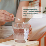 Vitamine C en poudre versée dans un verre d'eau : 2 cuillères doseuses dans la boisson de votre choix