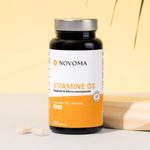 Pilulier de Vitamine D3 2000 UI Novoma sur fond jaune ensoleillé