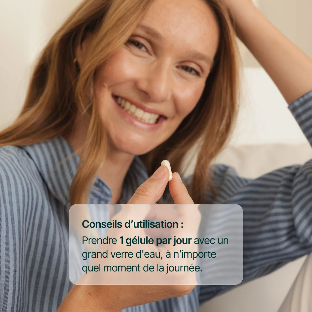 Femme souriante tenant une gélule de zinc : 1 gélule par jour avec un grand verre d'eau